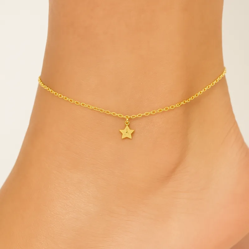 Yellow gold anklet featuring a delicate star charm, an elegant and refined piece worn around the ankle