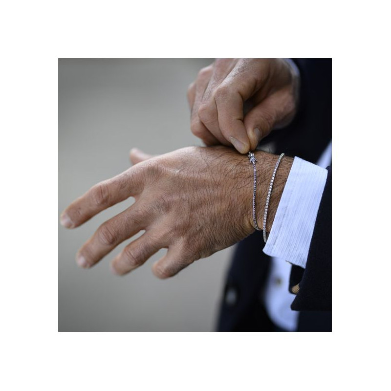 Zoom sur un bracelet homme en or blanc, ajusté avec soin à un poignet masculin habillé, symbole de raffinement et de cadeau personnalisé.