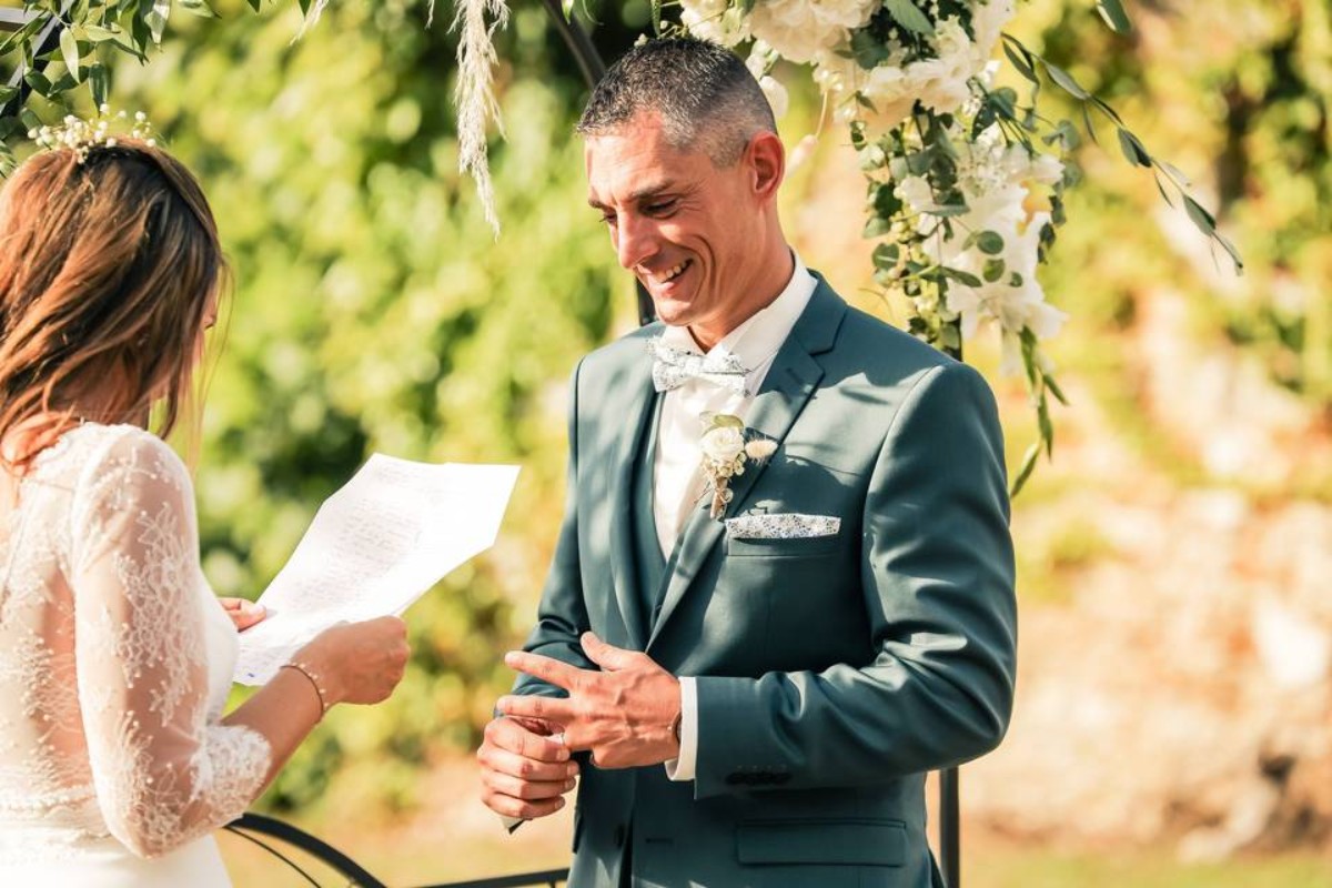 Mariés échangeant leurs vœux et alliances lors d’une cérémonie de mariage en extérieur, représentation d’un engagement sincère et d’une tradition européenne pleine d’émotion.