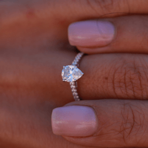 Solitaire pavé avec diamant poire et anneau serti de diamants ronds pour le pavage