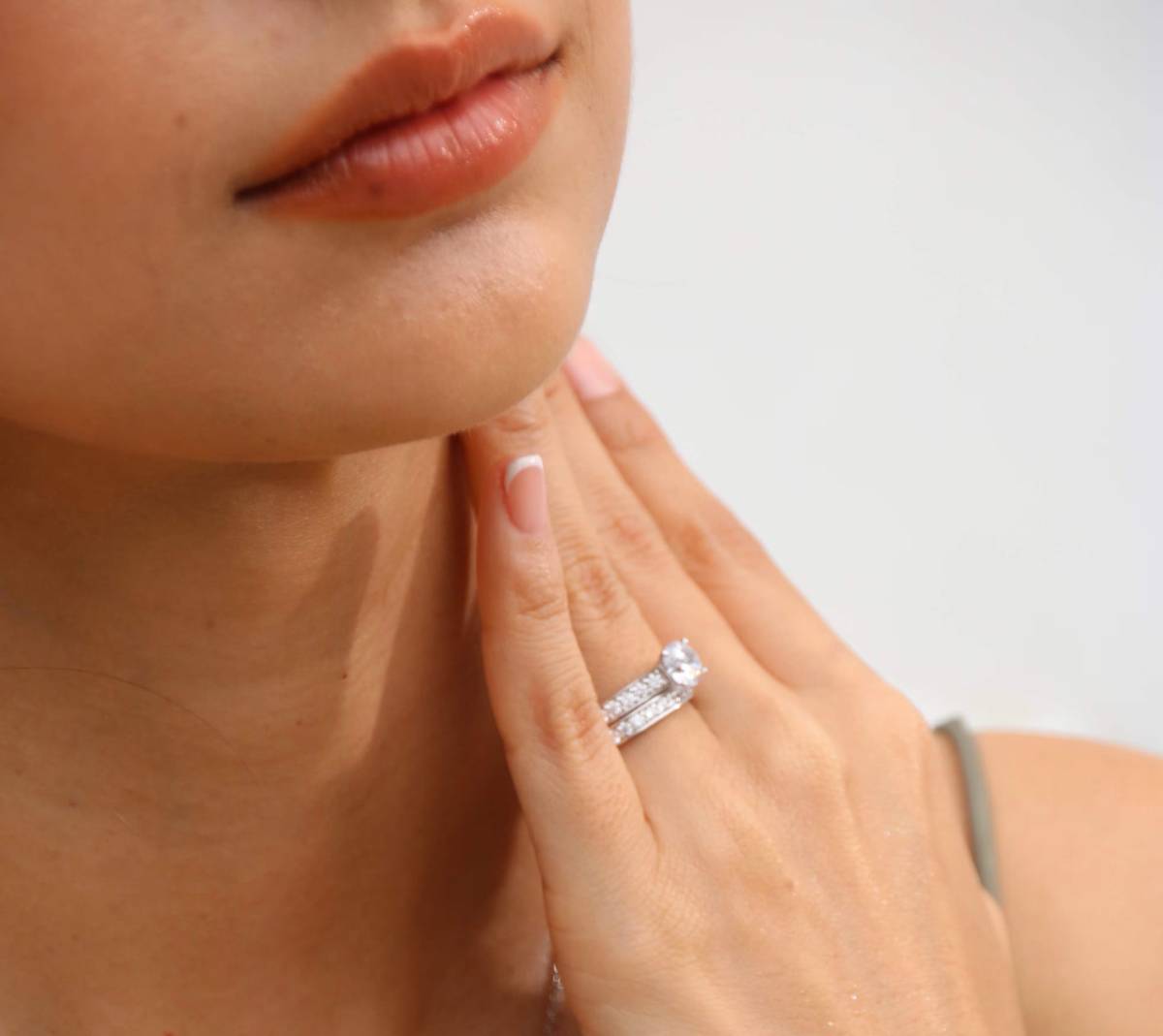 Main féminine portant une bague de fiançailles en diamant montée sur or blanc 18K avec double anneau pavé – bijouterie Celinni.