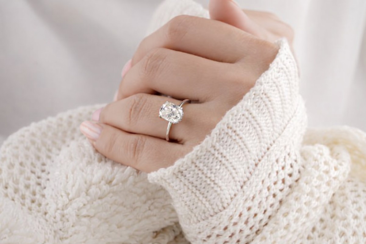 Witgouden solitaire verlovingsring met een cushion geslepen diamant, elegant gedragen om de hand te benadrukken.