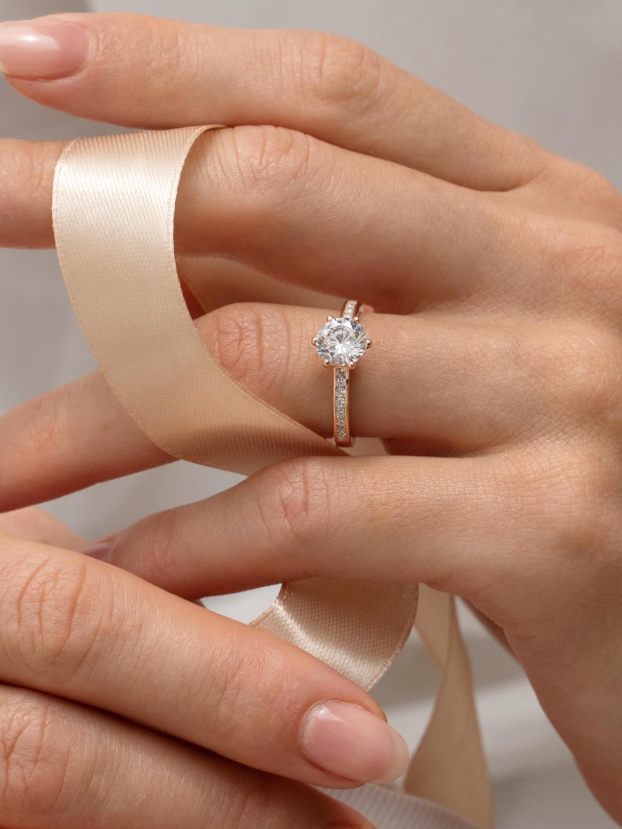 Mano de mujer con anillo de compromiso solitario en oro blanco con diamante redondo