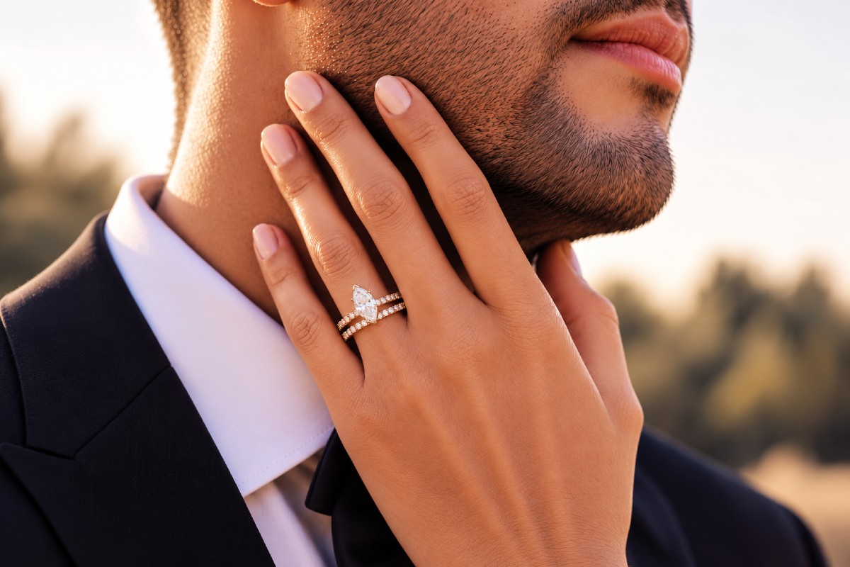 Hand einer Frau mit einem Diamant-Verlobungsring und einem Ehering in der Nähe des Gesichts ihres Partners.