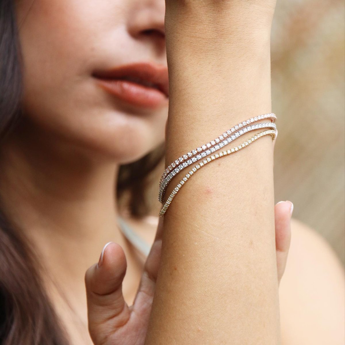 Pulsera fina de oro y diamantes en la muñeca, idea de joya simbólica para celebrar una boda de organdí y 7 meses de matrimonio.