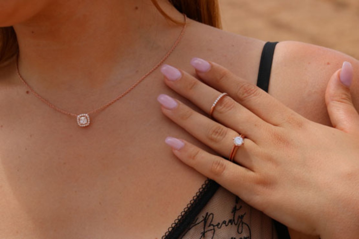 Vrouw die een hanger en ringen van Celinni draagt, vervaardigd in 18-karaats goud en bezet met diamanten – een luxueus cadeau-idee om in een adventskalender te verstoppen