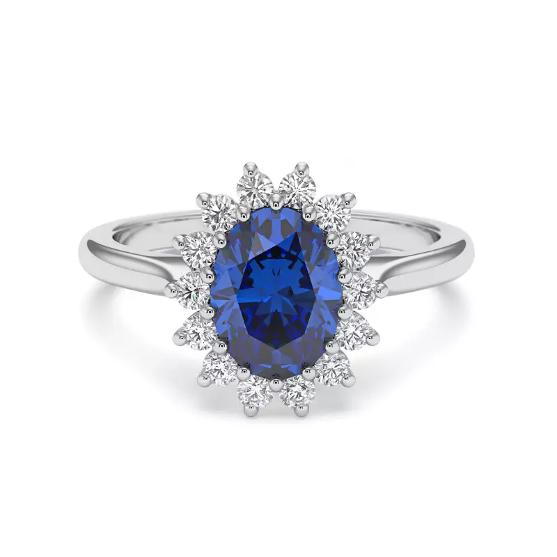 Une élégante bague en or blanc ornée d'un diamant bleu taille ovale, entourée d'un halo de diamants brillants.
