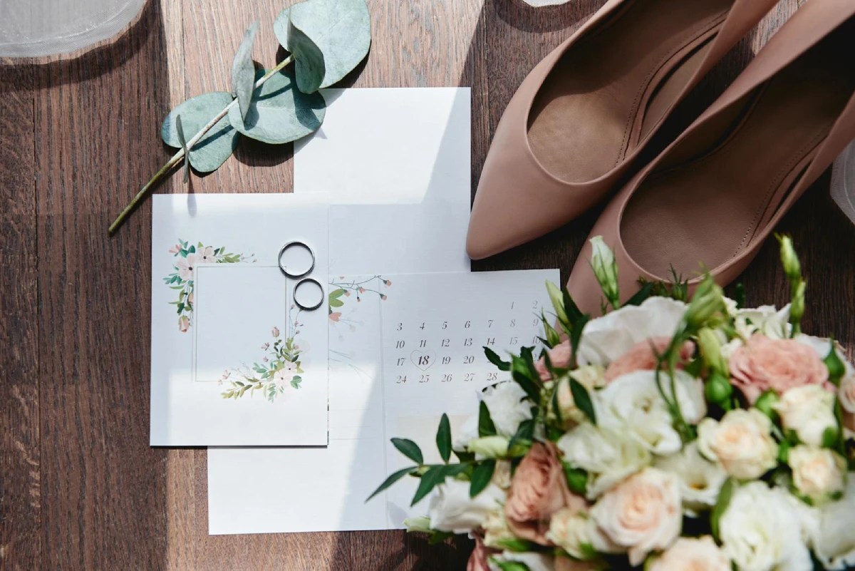 Faire-part de mariage avec motifs floraux, alliances et fleurs.