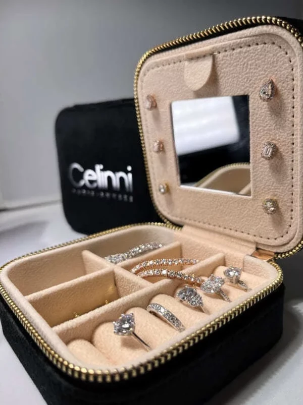 Celinni high-end jewelry box to store and protect your diamond jewelry. Black jewelry box lined with beige velvet, featuring compartments for rings, bracelets, and earrings, equipped with a mirror and the Celinni logo.