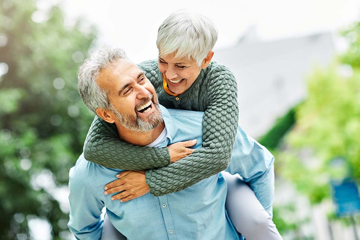 Un couple souriant et complice, symbole d’amour durable, pour illustrer la joie des noces de cuivre après 32 ans de mariage