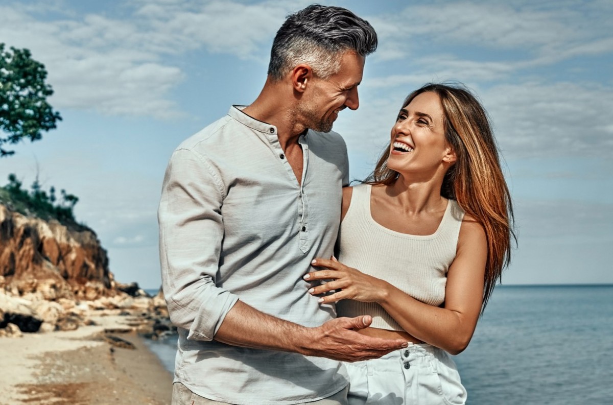 Couple amoureux profitant d’un moment romantique en bord de mer pour fêter leurs 14 ans de mariage, symbole des noces de plomb.
