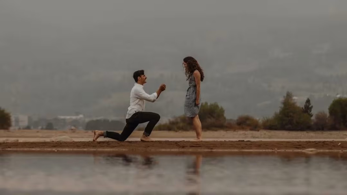 Jeune couple marié, front contre front, en extérieur, partageant un moment complice pour célébrer 1 an de mariage ; la douceur et la légèreté symboliques des noces de coton transparaissent dans cette scène romantique.