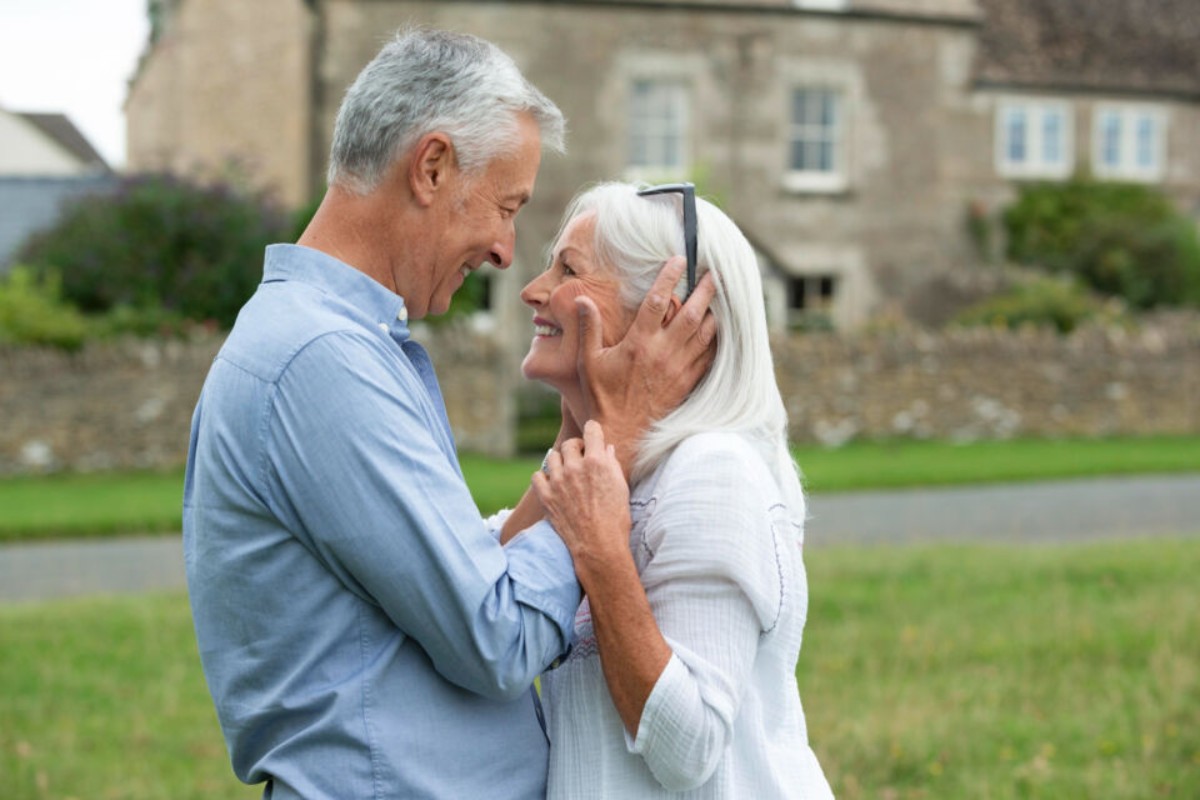 A senior couple looking at each other with love in a garden, symbolizing 44 years of marriage and the topaz wedding anniversary, embodying a lasting, sincere, and radiant bond.