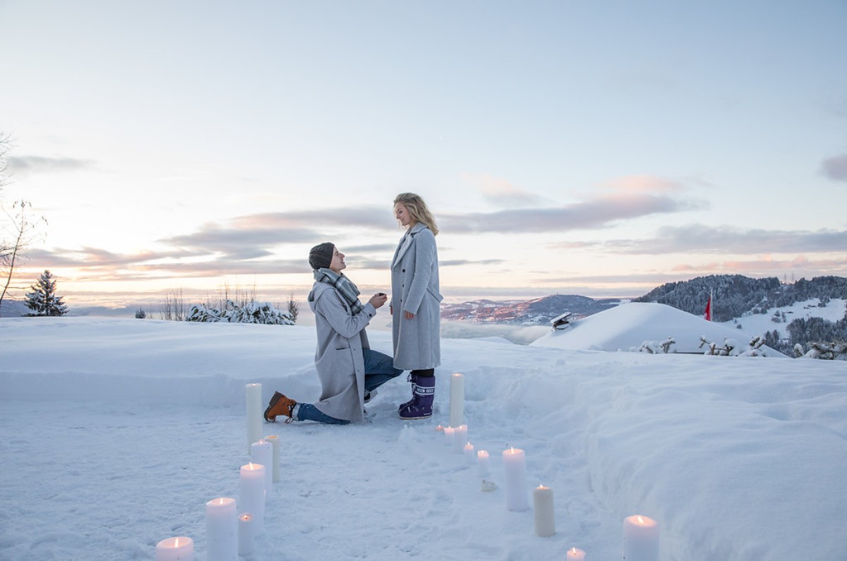 Marriage proposal in Switzerland set in a snowy landscape, featuring a romantic candlelit scene in the heart of the Swiss mountains.