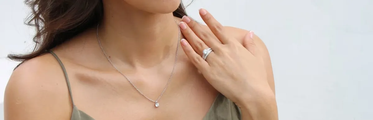 Vrouw die een fijne gouden ketting met diamanten hanger draagt, voorbeeld van een gouden sieraad dat regelmatig onderhoud nodig heeft om zijn glans te behouden.