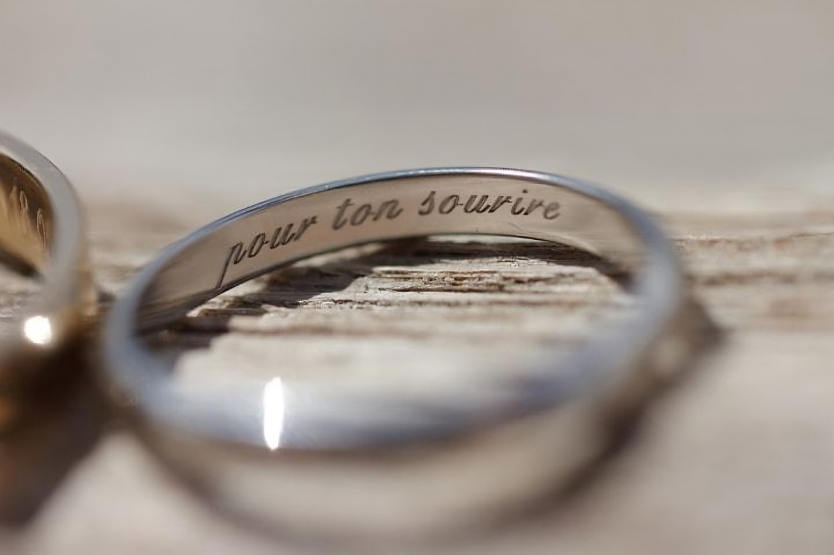 Close-up of a white gold ring engraved on the inside with the tender message "for your smile".