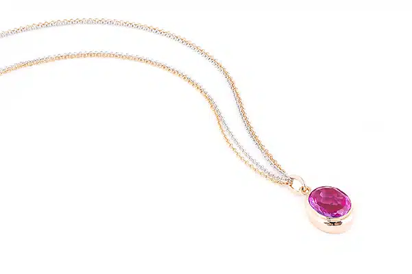 Femme portant un collier avec un pendentif en saphir rose