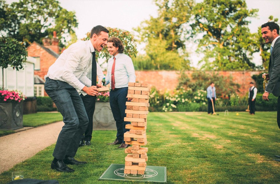 Invités jouant à un jeu en bois géant lors d’un mariage, une animation conviviale et ludique pour briser la glace entre les convives en plein air.