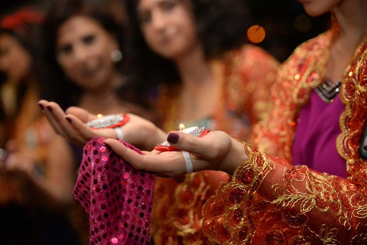 Kına Gecesi: vrouwen in traditionele kleding met kaarsen in de hand – Turks hennaritueel | Celinni Vrouwen, gekleed in traditionele outfits versierd met gouden borduursels, houden brandende kaarsen in hun handen tijdens de hennaceremonie Kına Gecesi, een sleutelmoment in het Turkse huwelijk.
