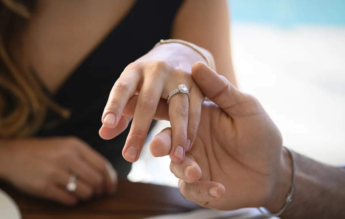 Main d’une femme portant une bague de fiançailles en diamant à la main droite, illustrant la symbolique moderne du bijou et sa signification personnelle.