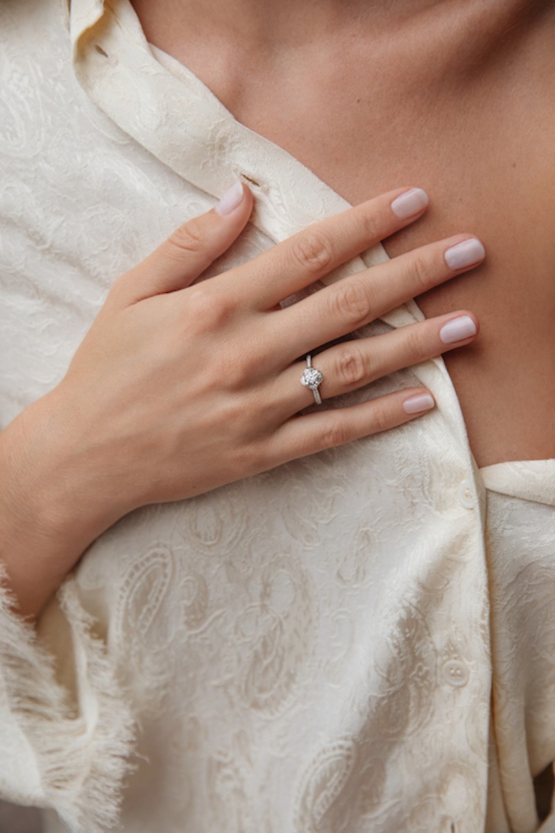 Bébé vêtu de blanc portant une médaille de baptême en or 18 carats, symbole de protection et de transmission lors du baptême