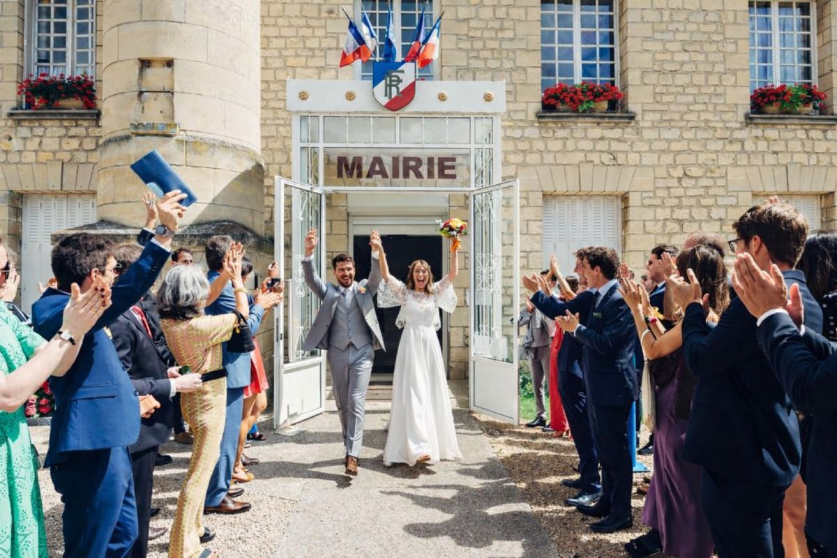 Pareja de recién casados celebrando su matrimonio civil en Francia a la salida del ayuntamiento, rodeados de sus invitados durante una ceremonia civil.