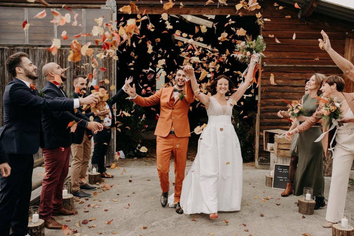Pareja de novios celebrando su unión durante una boda insólita al aire libre, rodeados de sus invitados en un ambiente natural y acogedor.