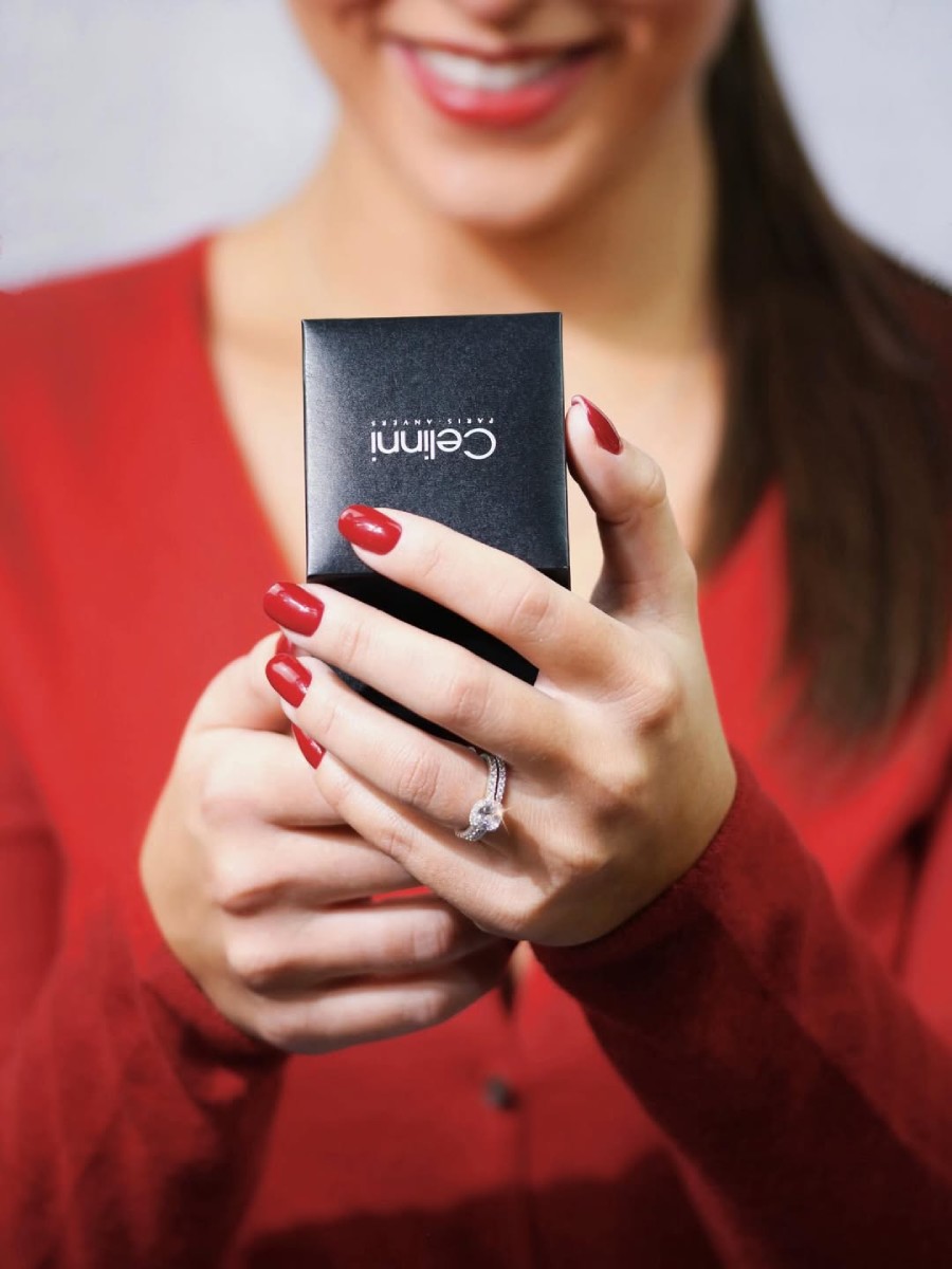 Femme tenant un écrin Celinni contenant une bague de fiançailles en diamant, symbole d’une demande en mariage élégante et raffinée en Suisse.