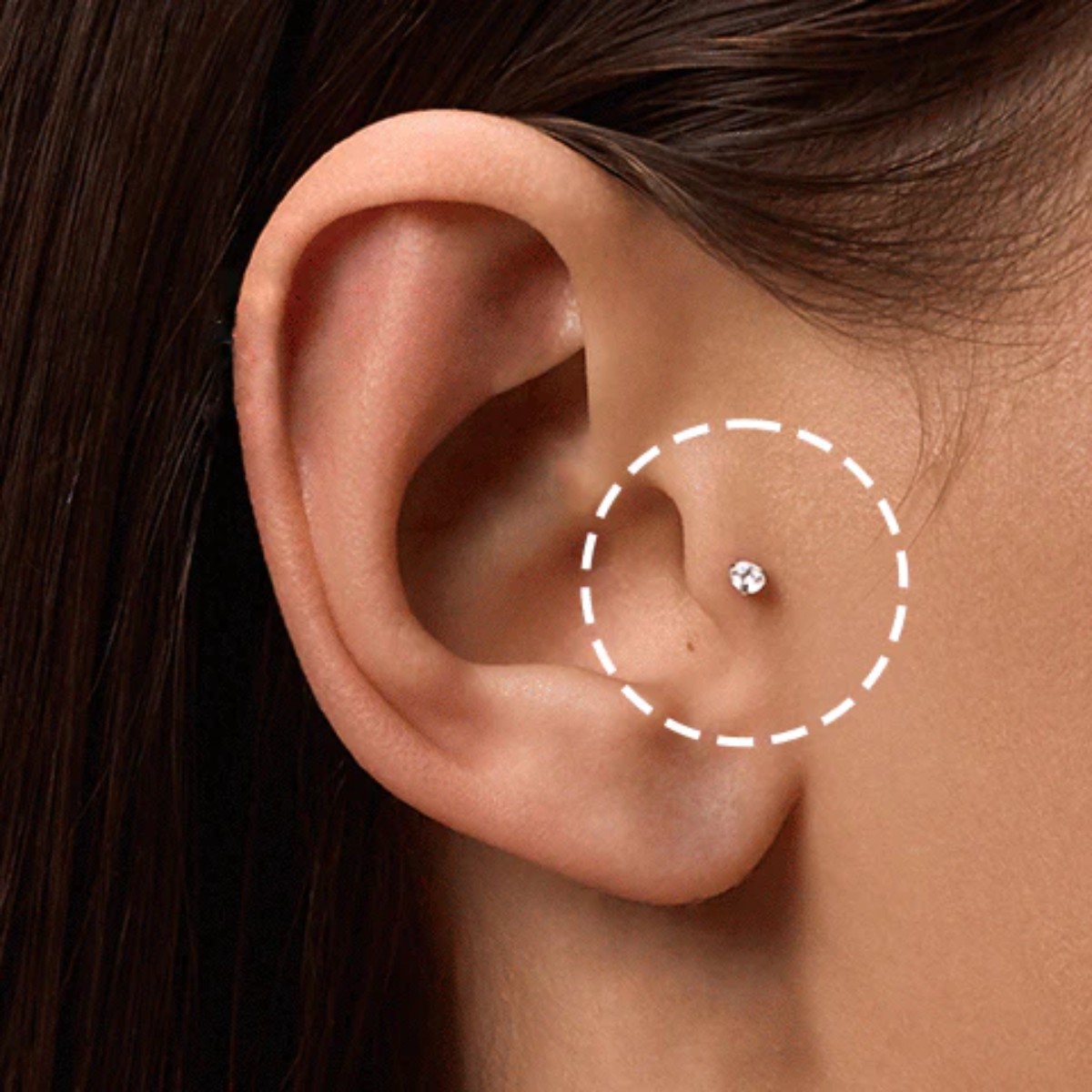 Close-up of a tragus piercing on the ear cartilage, adorned with an 18-carat gold jewel set with a natural diamond, illustrating elegance and refinement in Celinni style.