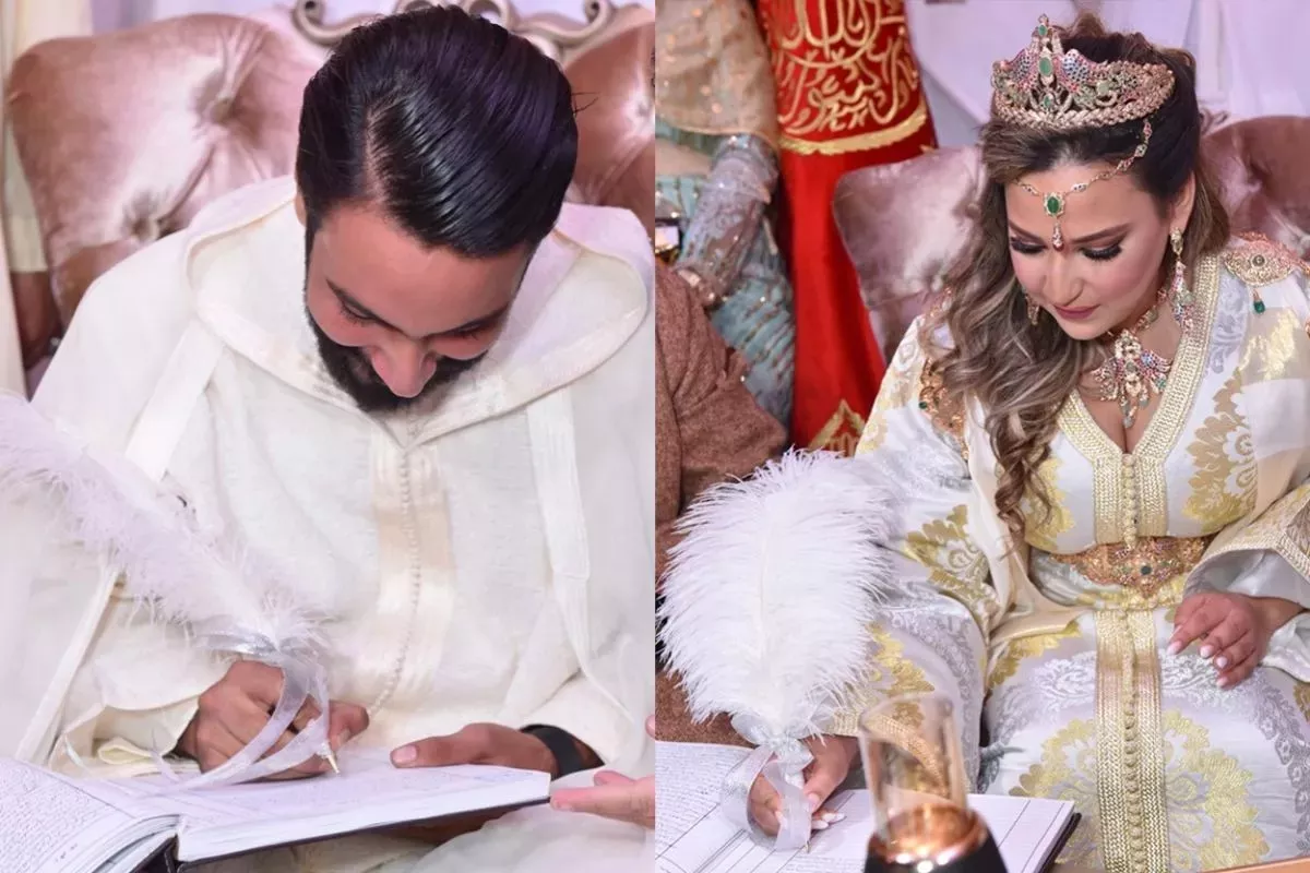 Bruid en bruidegom ondertekenen hun huwelijksakte met een witte veer, gekleed in traditionele Marokkaanse kleding – symbool van de voorbereidingen en de officiële verbintenis tijdens een huwelijk.