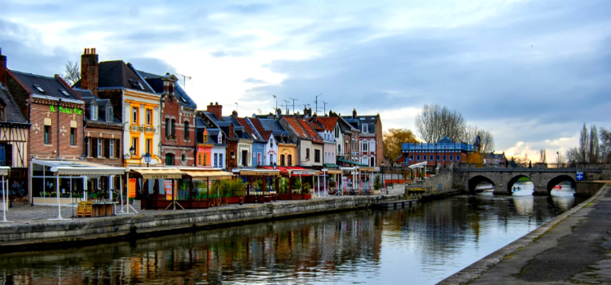 Gekleurde huizen en terrassen aan de rivier in een Frans dorp, een authentieke en charmante omgeving voor een romantisch uitje tijdens een huwelijksreis in Frankrijk